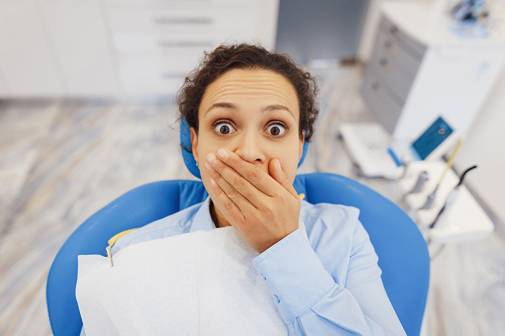 dental anxiety woman scared sitting in dentist chair